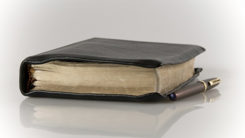 Una Biblia y una pluma sobre una mesa
