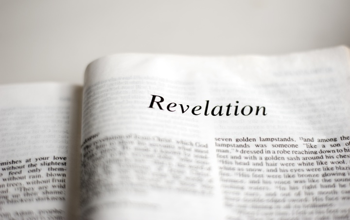 A Bible opened to first page of Revelation.