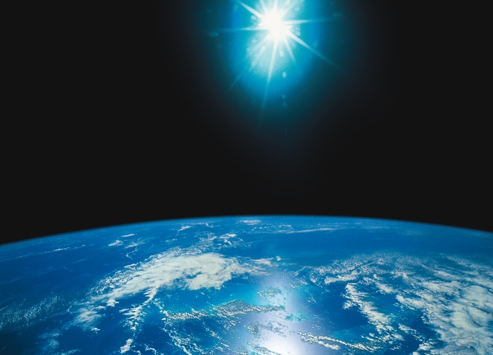 Photo illustration of bright light above the earth.