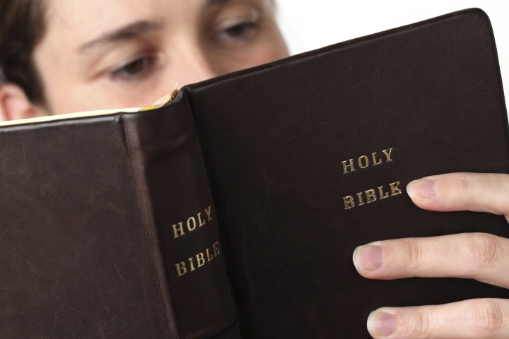 A person looking at a Bible.