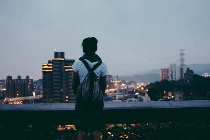 A young woman looking over a crowded city.
