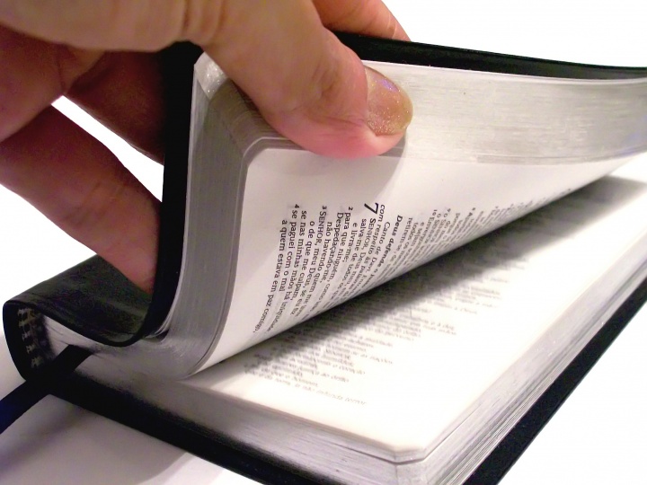 Una persona hojeando una Biblia