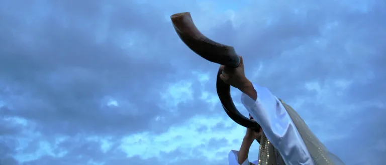 A person blowing a shofar.