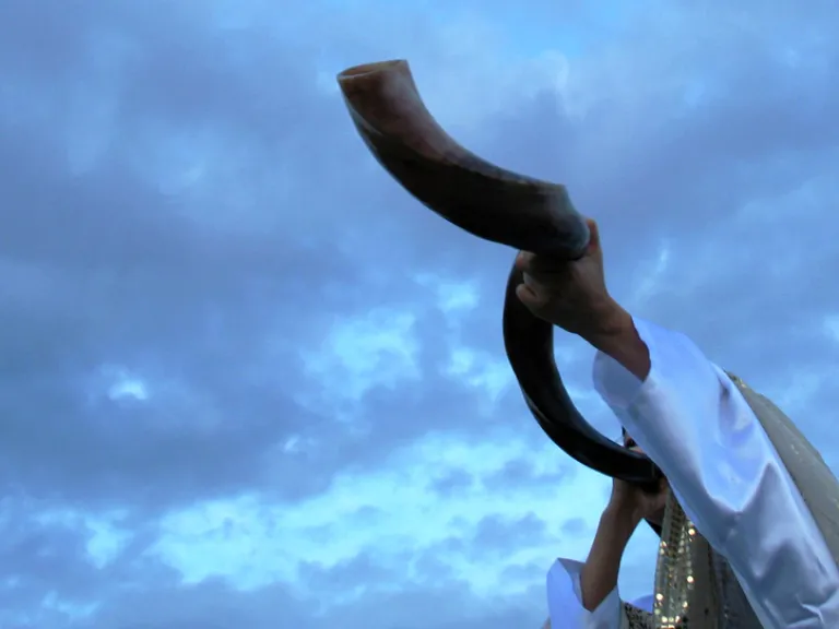A person blowing a shofar.