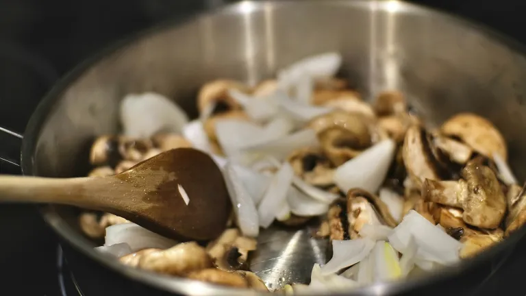 Vegetable and mushrooms being sauted in a pan.