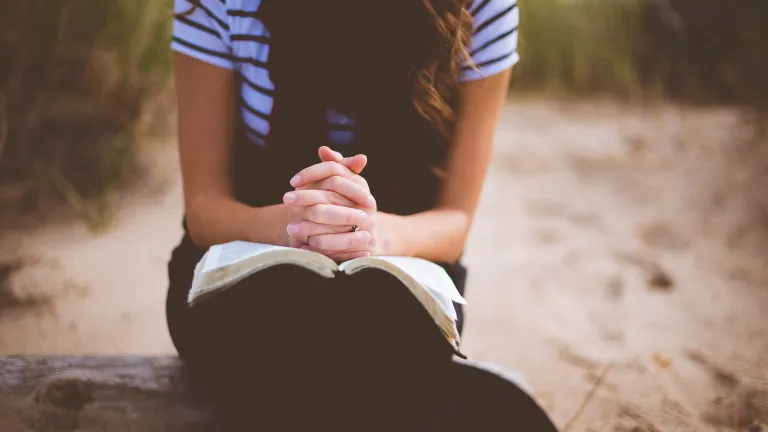 A woman with an open Bible on her lap.
