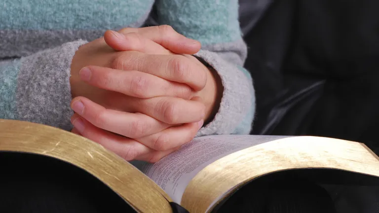 Covenants are simply binding agreements between two or more parties. A Bible on a person's lap.