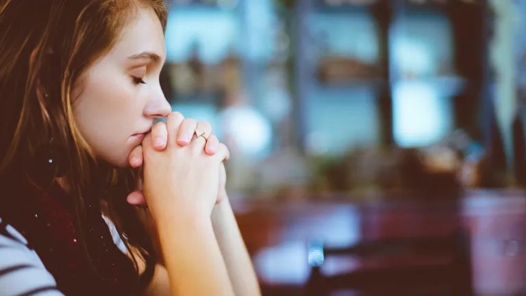 A young woman praying.