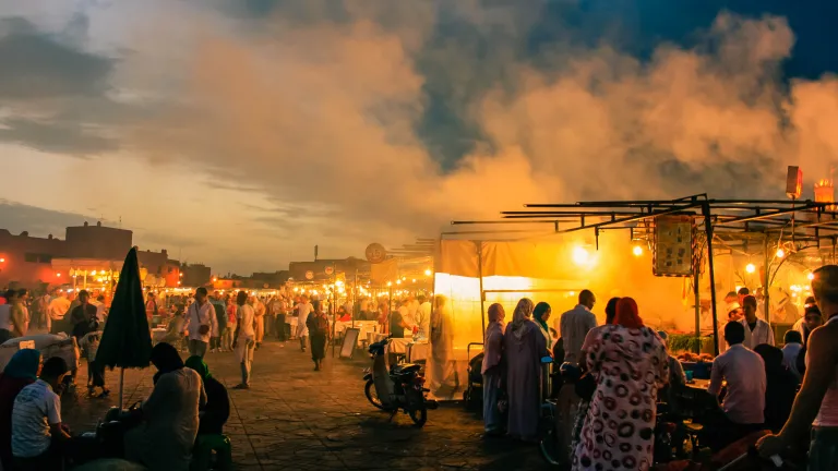Large groups of people in an open air market.