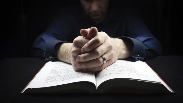Fasting is an important part of building a right and strong relationship with God. A man praying over his Bible.