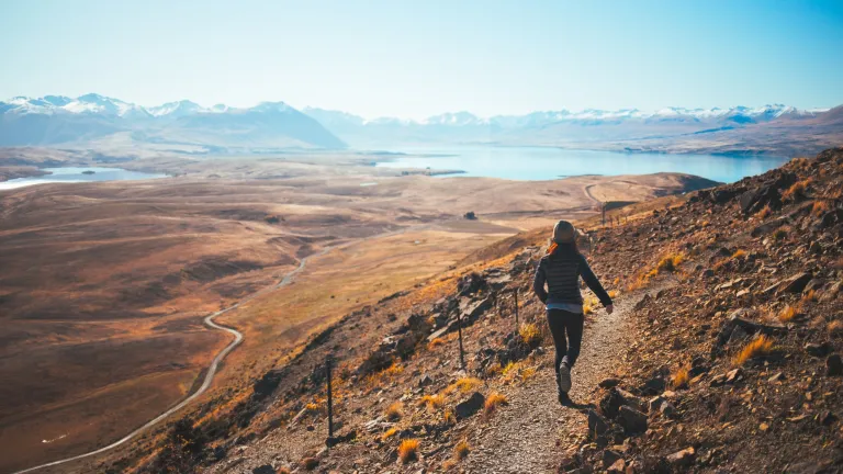Hebrews 12:1-2 tells us, “Let us run with endurance the race that is set before us . . .” It’s not enough to train for a big race. It’s not enough to start a race. What really counts is crossing the finish line. A woman running on a rugged trail on a mountain side.