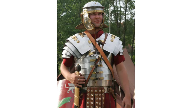 El soldado romano con su armadura puesta: su túnica, coraza, sandalias, casco, escudo y espada.