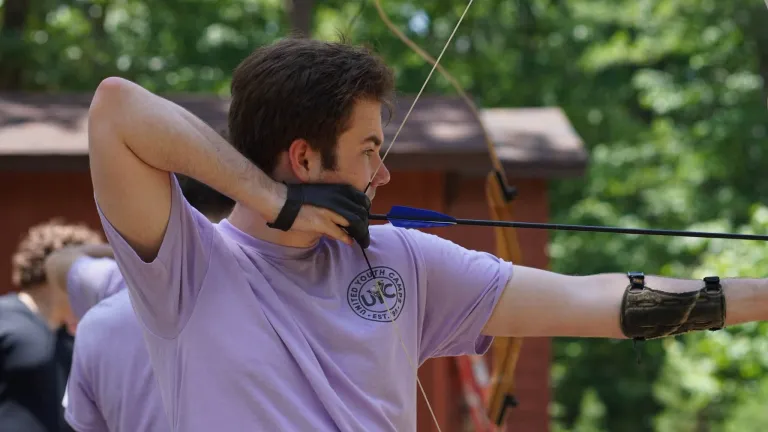 a young man aiming a bow and arrow