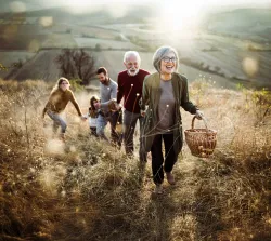 A multi generation family walking in a field.